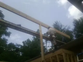 Carpenter setting a ridge beam over a new addition frame — Ice Dam Removal by Roofing Brothers in Rocky Ridge
