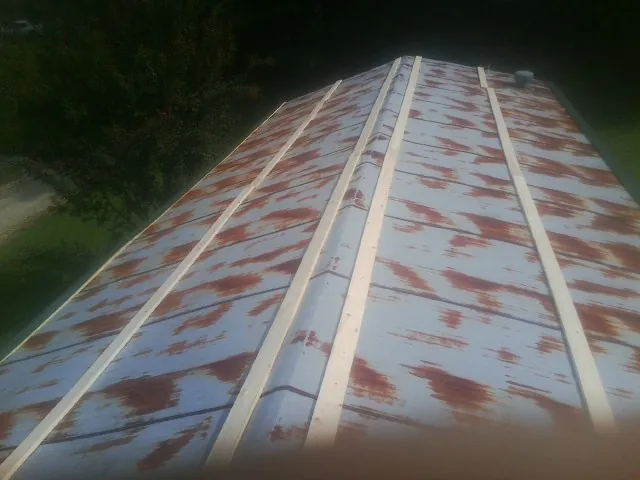 Rusted metal roof panels with new wood purlins before replacement — Storm Damage Roof Repair in Rocky Ridge by Roofing Brothers