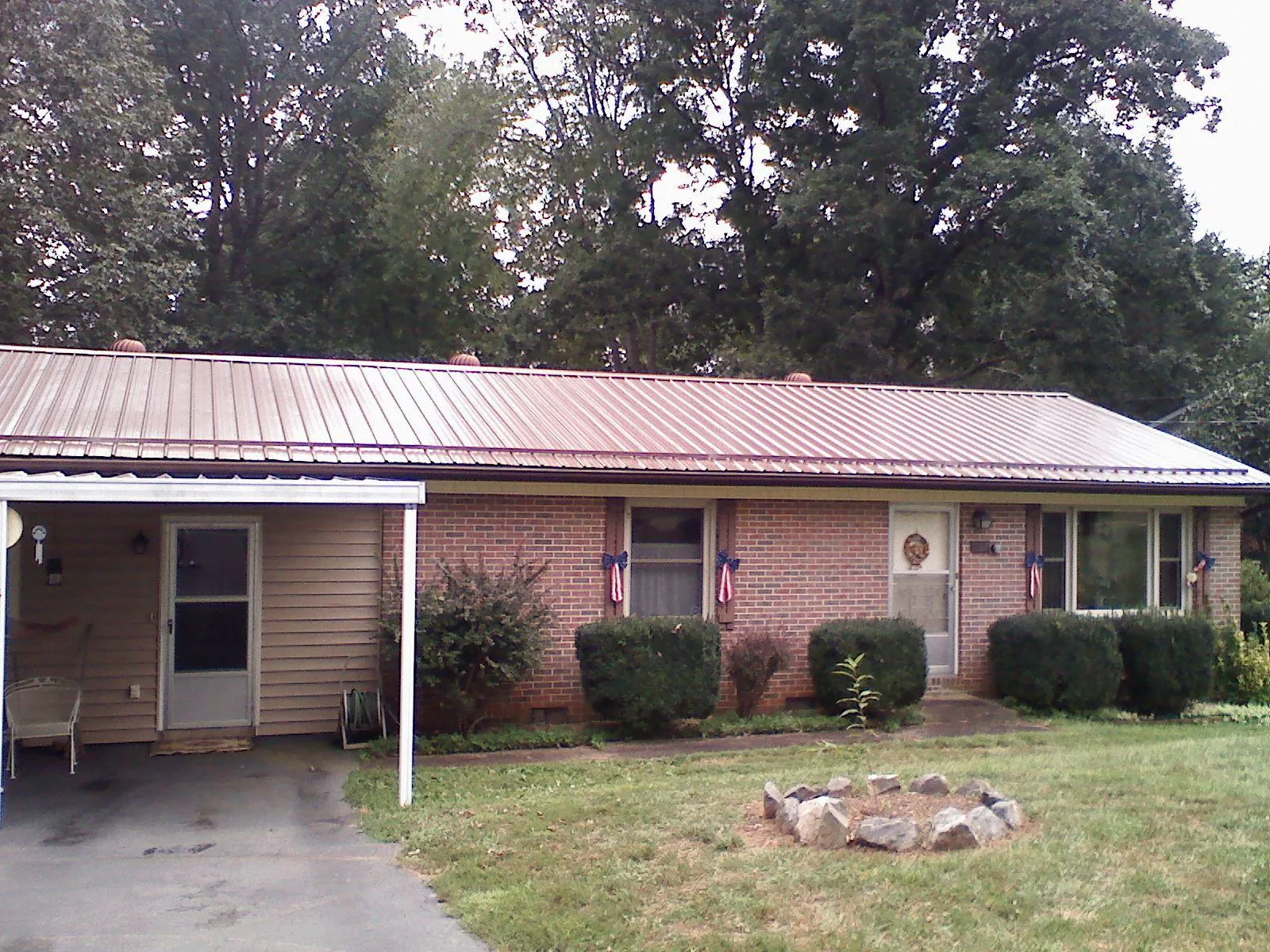 Bronze metal roof and carport on a brick ranch home — Roof Repair work by our crew in Rocky Ridge